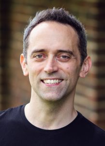 Bass Trevor Eliot Bowes is a young white man with short black hair,
